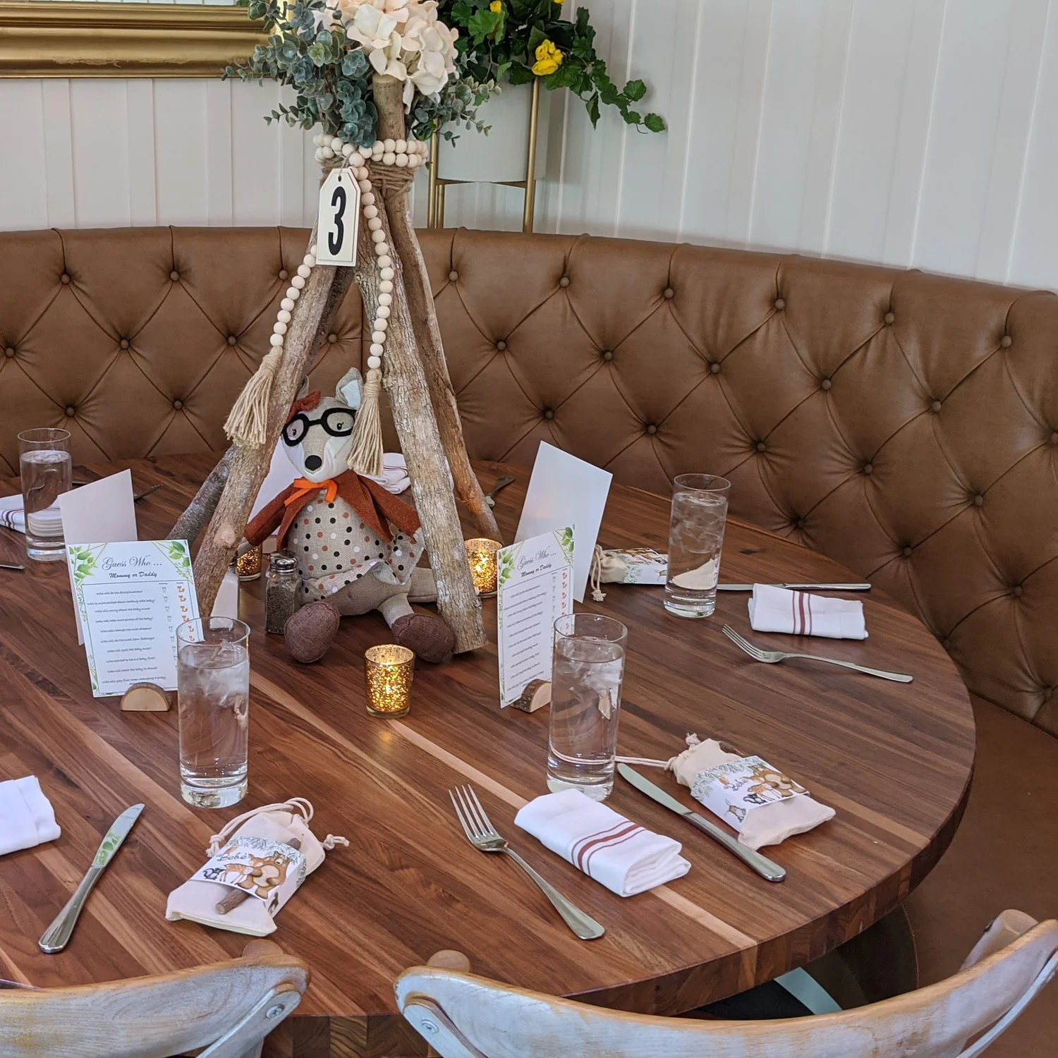 An afternoon shower table at DeNovo Edgewater set with a woodland centerpiece and party favors.