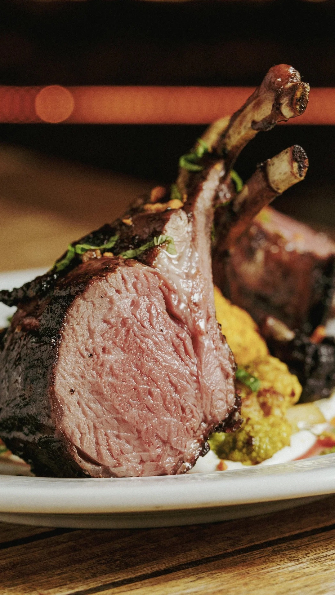 A grilled Australian lamb chop carved to a rosy center, plated with parsnip purée and chard at DeNovo Edgewater.