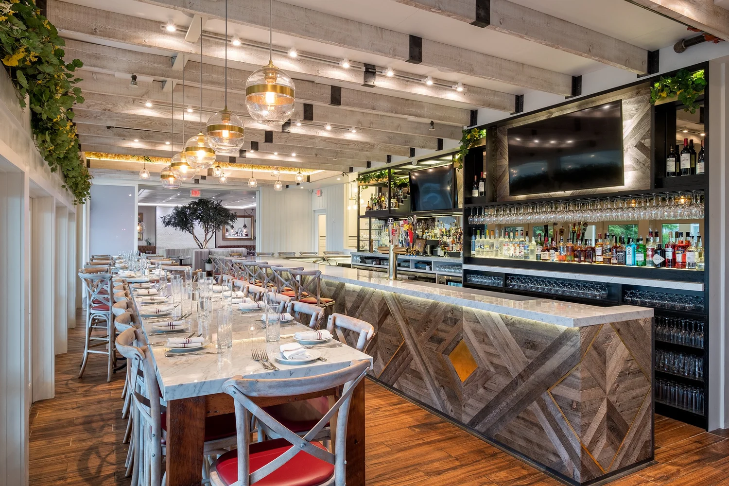 The main dining room and reclaimed-wood bar with a marble top and globe pendant lights.